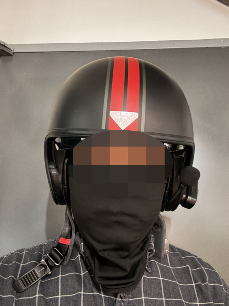 Front-facing view of a rider wearing a standard motorcycle helmet