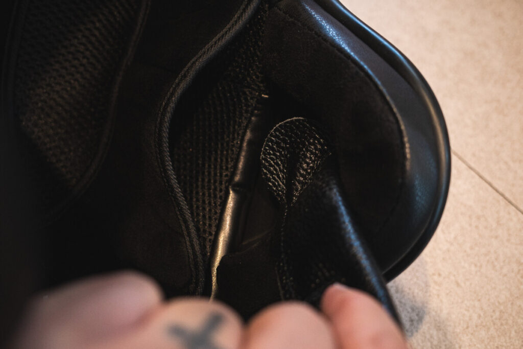 "Close-up view of the interior of a motorcycle helmet, showing the mesh lining and speaker compartment area."