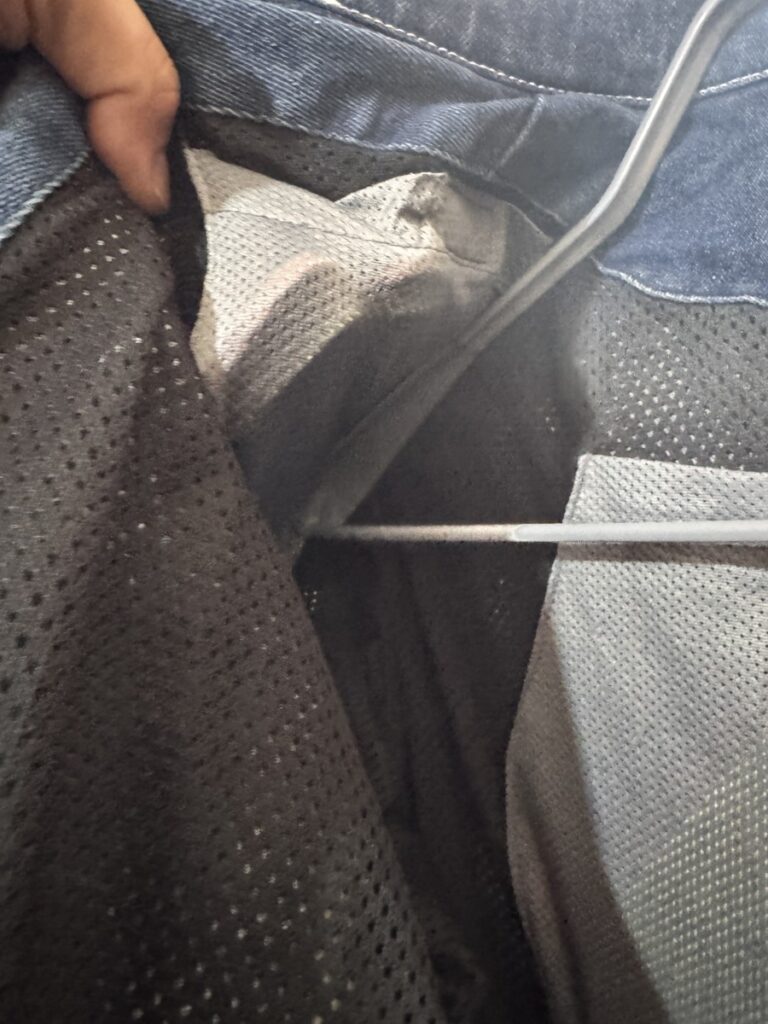 Shoulder protector insertion point inside the jacket, with visible mesh lining and zipper access