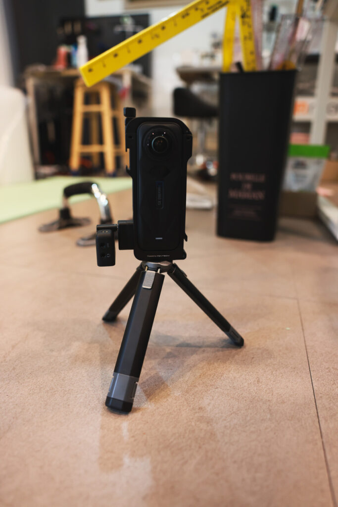 “Three photos showing the Insta360 X5 mounted on a mini tripod with the mic adapter attached, and a side view of the setup with a hand holding the camera.”