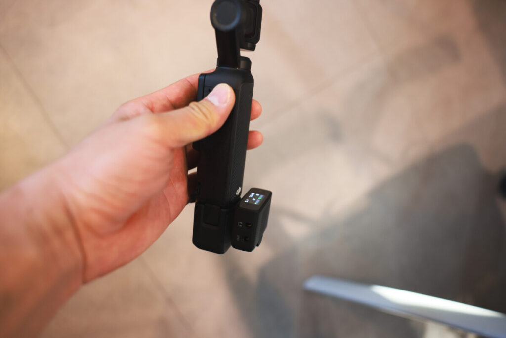 “Three photos showing the Insta360 X5 mounted on a mini tripod with the mic adapter attached, and a side view of the setup with a hand holding the camera.”