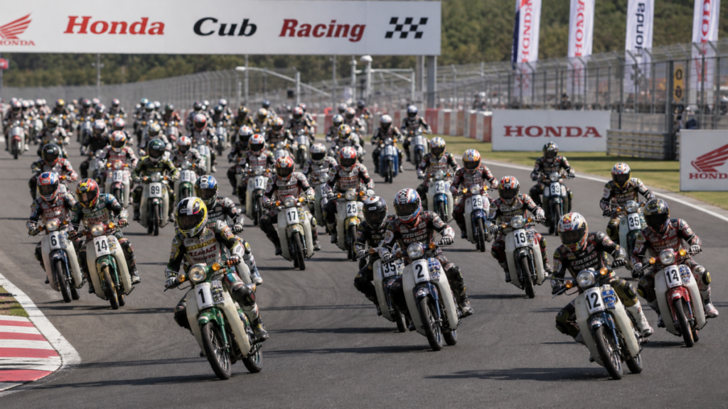 Large group of Honda Super Cubs racing together on circuit track worldwide
