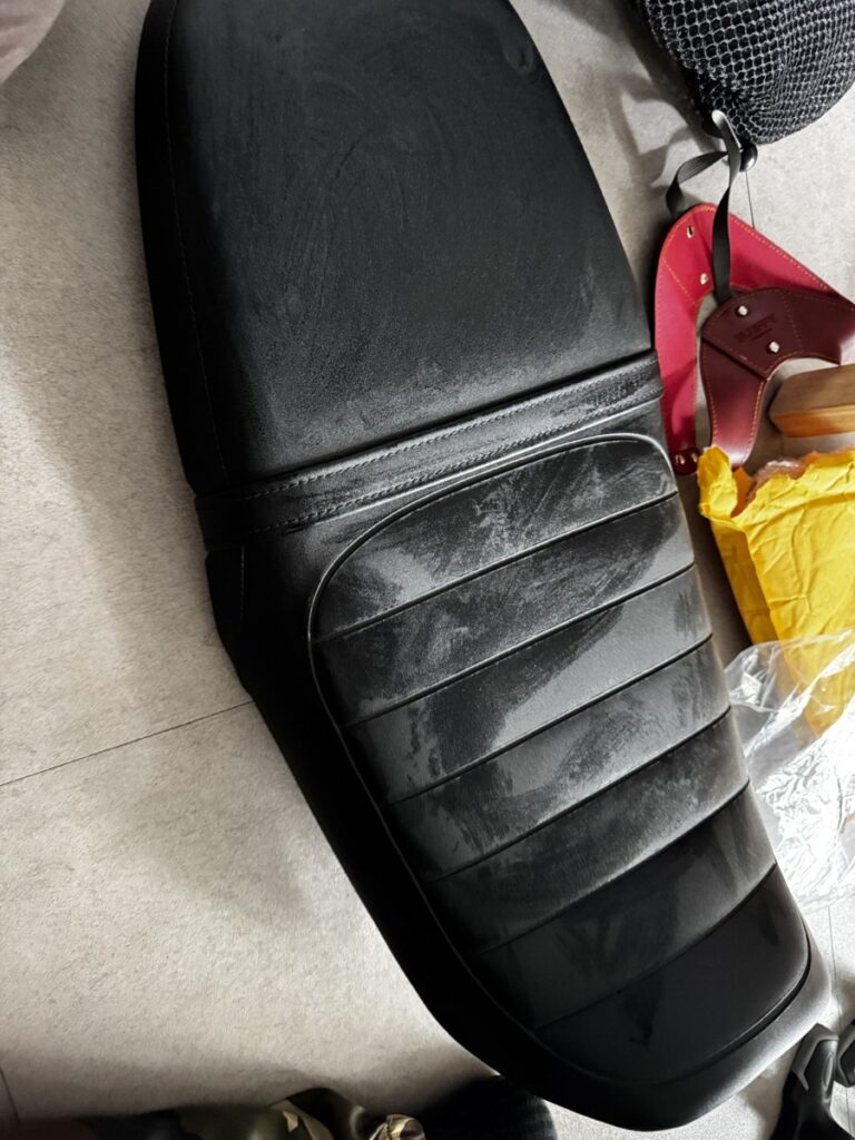 Stretching the seat cover tightly over the Honda CL500 seat during installation-1