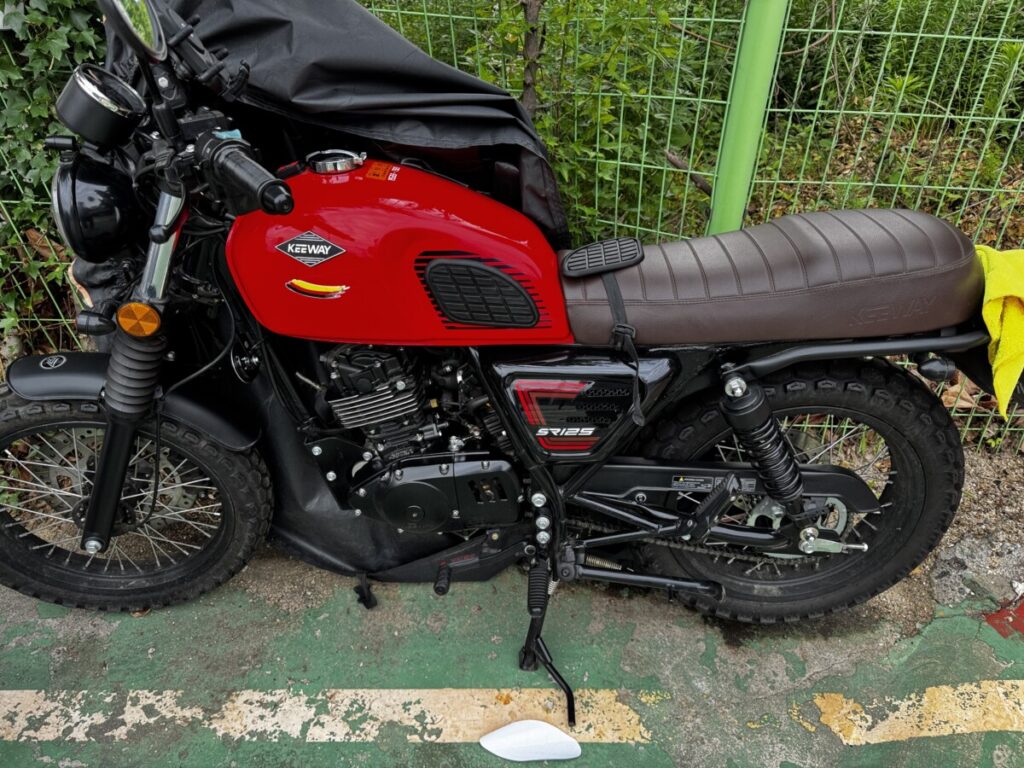Keeway SR125 with vintage-style side tank pads installed on a red motorcycle tank