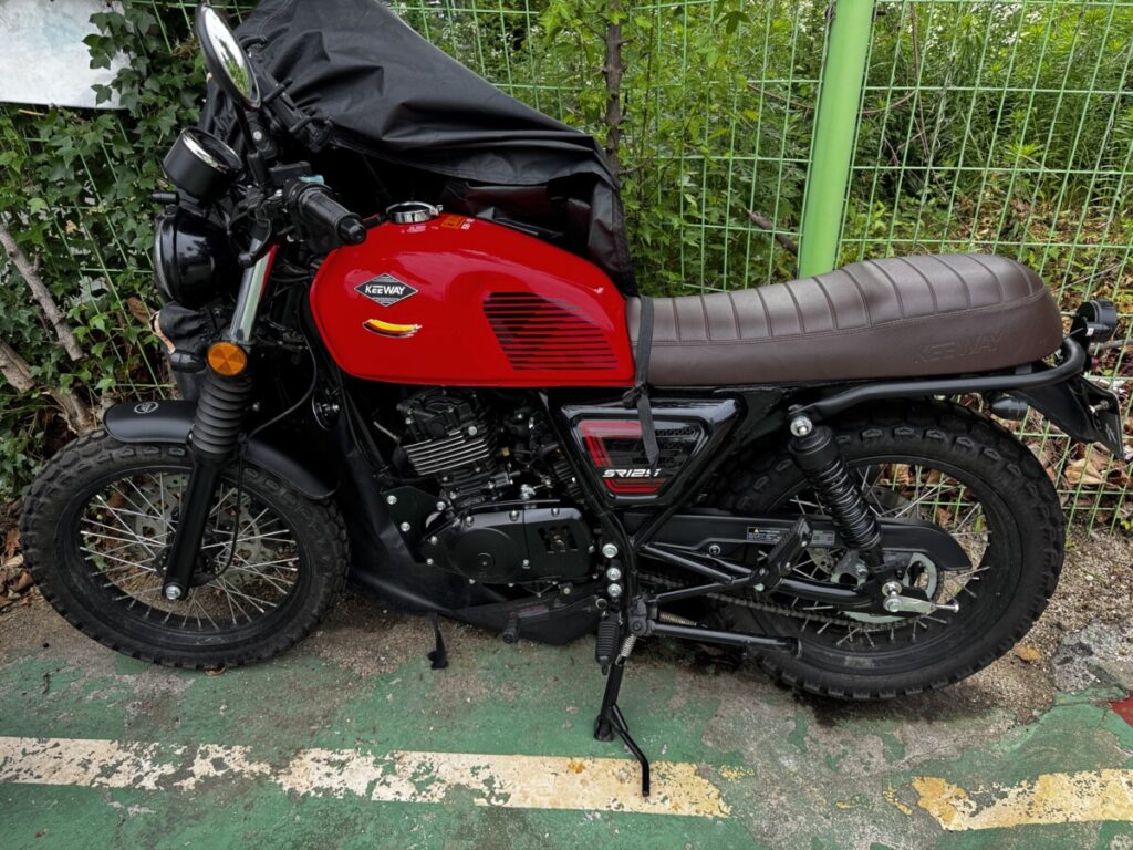 Finished side view of a red Keeway SR125 with black vintage tank pads installed